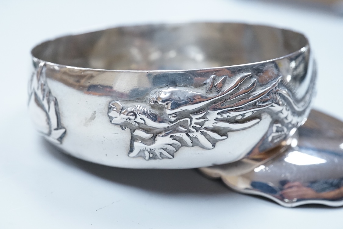 An early 20th century Chinese Export white metal small trinket dish with dragon decoration, by Sing Fat, diameter 66mm, together with a larger Chinese Export white metal trinket dish, maker Tien Shing?.